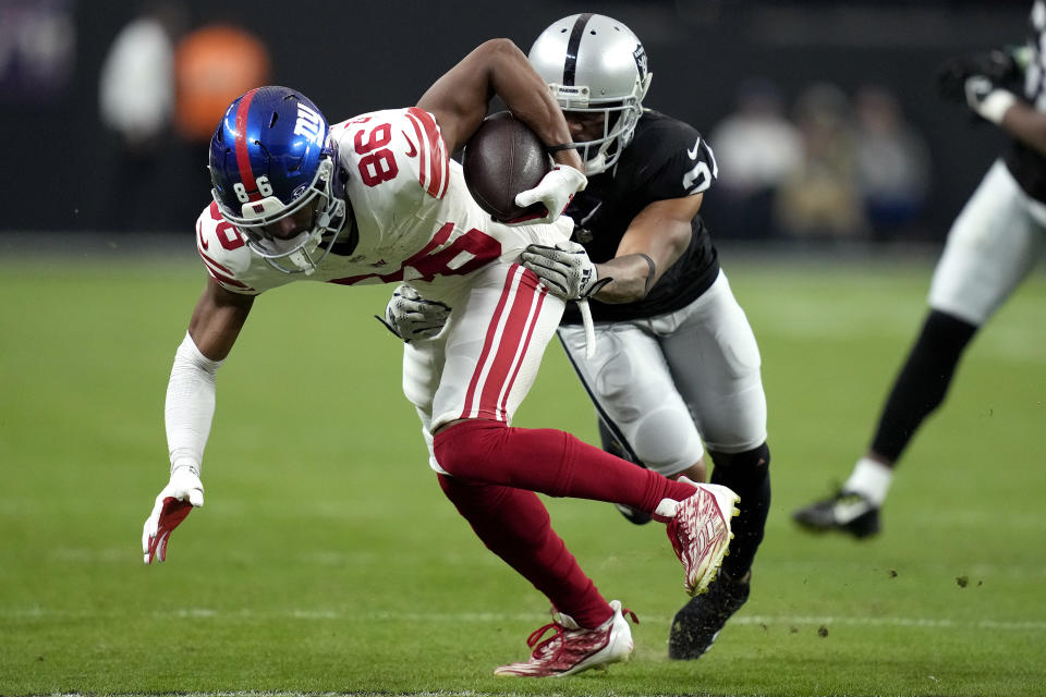 New York Giants wide receiver Darius Slayton (86) is tackled by Las Vegas Raiders cornerback Marcus Peters (24) during the second half of an NFL football game, Sunday, Nov. 5, 2023, in Las Vegas. (AP Photo/John Locher)