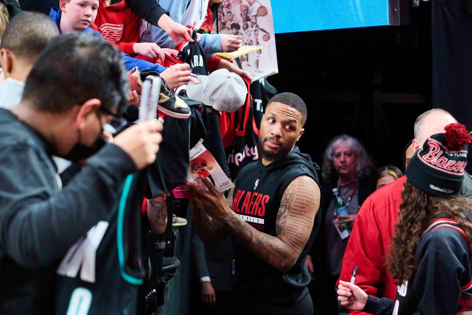 Trail Blazers guard Damian Lillard signs autographs before a game.