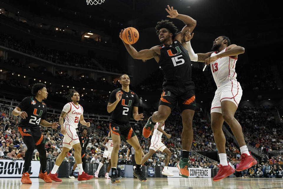 Miami forward Norchad Omier vies for the ball with Houston forward J'Wan Roberts in the second half of a Sweet 16 college basketball game in the Midwest Regional of the NCAA Tournament Friday, March 24, 2023, in Kansas City, Mo. (AP Photo/Charlie Riedel)