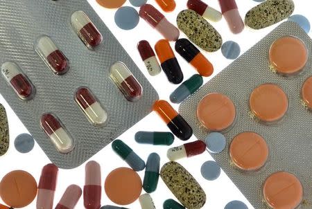 Pharmaceutical tablets and capsules in foil strips are arranged on a table in this picture illustration taken in Ljubljana September 18, 2013. REUTERS/Srdjan Zivulovic