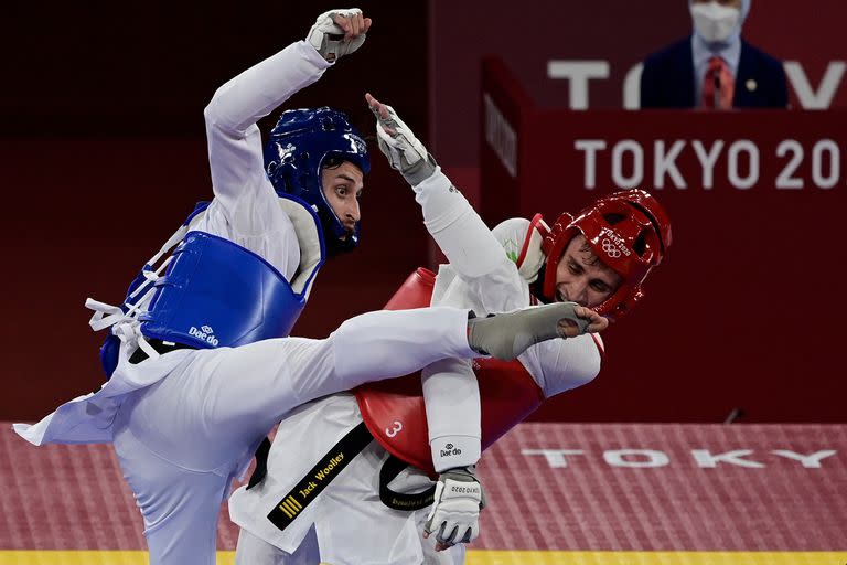 El argentino Lucas Lautaro Guzmán (azul) y el irlandés Jack Woolley (rojo) compiten en la ronda eliminatoria masculina de taekwondo de -58 kg durante los Juegos Olímpicos de Tokio 2020 en el Makuhari Messe Hall de Tokio el 24 de julio de 2021,