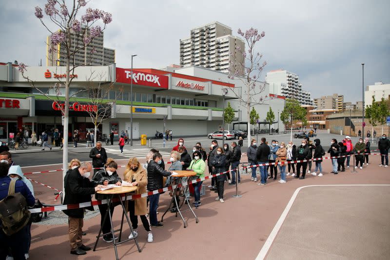 People wait to get vaccinated at mobile vaccination centre in Cologne