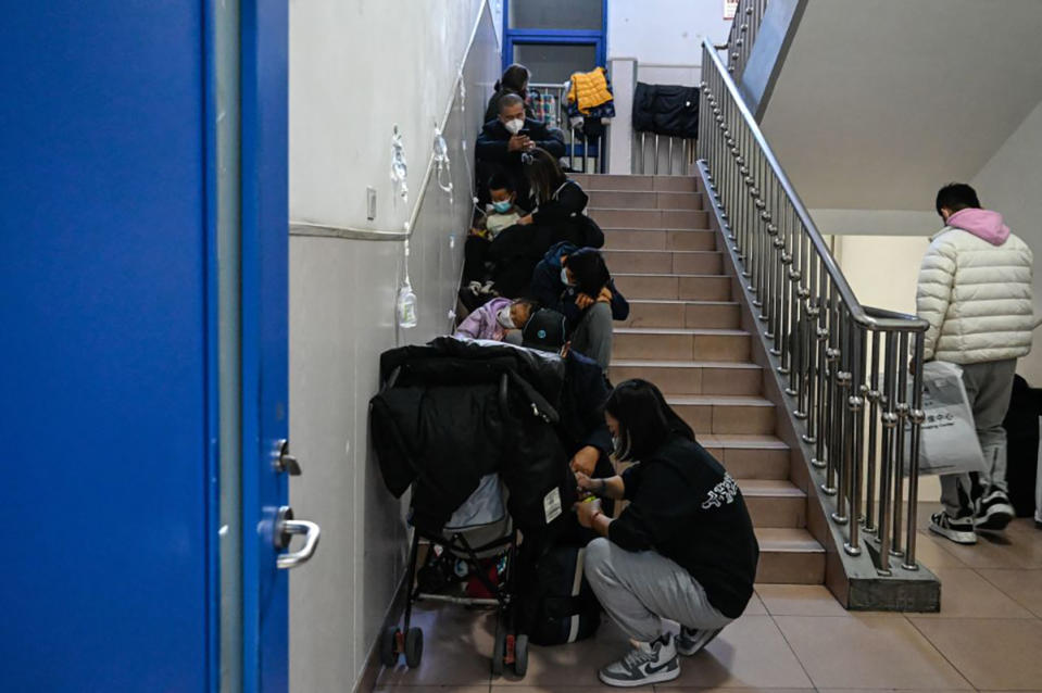 Children receive a drip on the stairs at a children hospital in Beijing on November 23, 2023. 