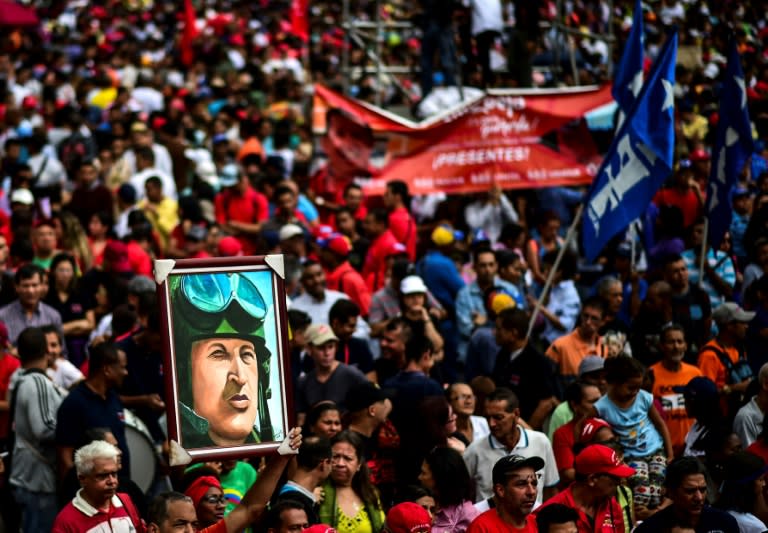 A pro-government activist holds a portrait depicting late Venezuelan President Hugo Chavez during a rally in Caracas, on August 14, 2017