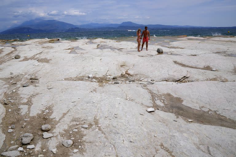 Una pareja camina en la península de Sirmione, en el lago de Garda, Italia, el viernes 12 de agosto de 2022