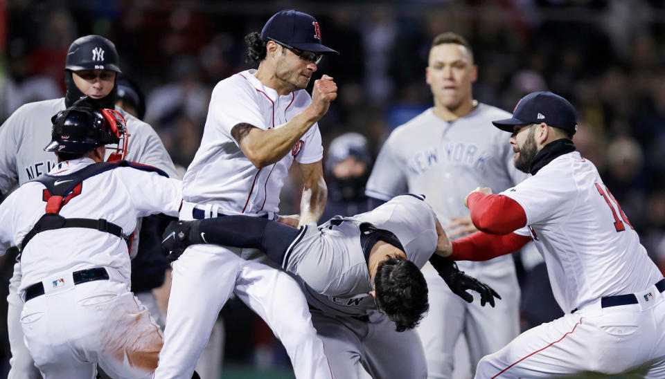 Boston Red Sox relief pitcher Joe Kelly, left, throws a punch at New York Yankees’ Tyler Austin, center, as they fight during the seventh inning of a baseball game at Fenway Park in Boston, Wednesday, April 11, 2018. At right is Boston Red Sox first baseman Mitch Moreland. (AP Photo/Charles Krupa)