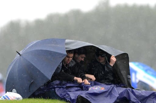 Spectators try to stay dry during the qualifying session at the Silverstone circuit on July 7 ahead of the British Formula One Grand Prix. Silverstone's managing director has vowed to carry on in his job as the circuit started counting the cost of last weekend's rain-marred British Grand Prix