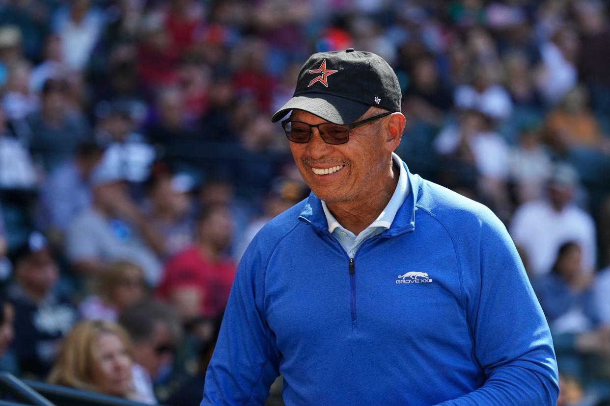 Hall of Fame baseball player Reggie Jackson smiles at fans as he takes his seat in the stadium during the fifth inning of a baseball game between the Arizona Diamondbacks and Houston Astros, Wednesday, April 13, 2022, in Phoenix. (AP Photo/Ross D. Franklin)