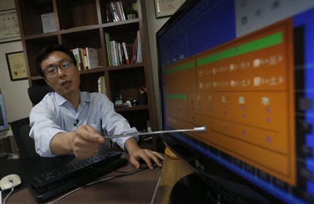 Fortune teller Song Byung-chang looks at a child's fate, or Saju in Korean, at his office in Seoul August 6, 2013. REUTERS/Kim Hong-Ji