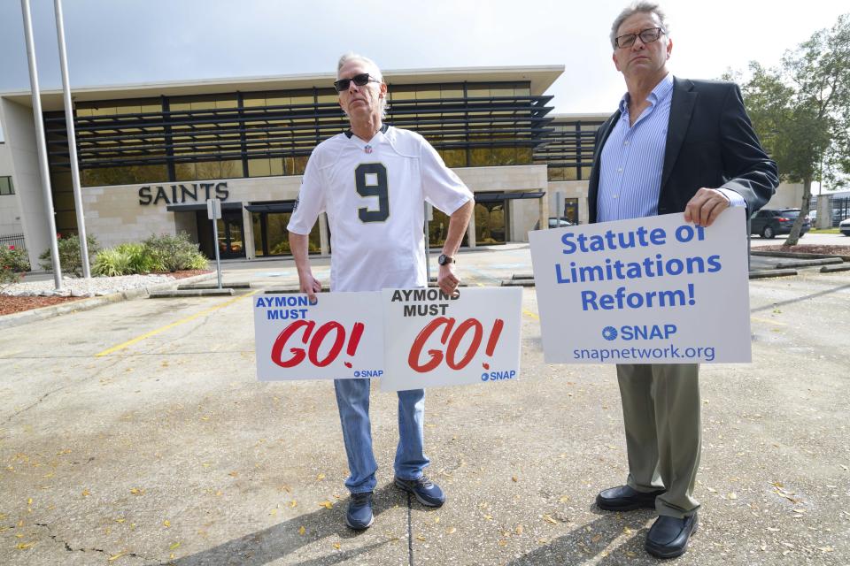 FILE - Members of SNAP, the Survivors Network of those Abused by Priests, including Richard Windmann, left, and John Gianoli, right, hold signs during a conference in front of the New Orleans Saints training facility in Metairie, La., Wednesday Jan. 29, 2020. On Thursday, Sept. 7, 2023, a Louisiana state grand jury charged a now-91-year-old disgraced priest, Lawrence Hecker, with sexually assaulting a teenage boy in 1975, an extraordinary prosecution that could shed new light on what Roman Catholic Church leaders knew about a child sex abuse crisis that persisted for decades and claimed hundreds of victims. (AP Photo/Matthew Hinton, File)