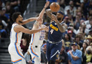 Denver Nuggets center DeMarcus Cousins, right, passes the ball as Oklahoma City Thunder center Olivier Sarr, left, and guard Vit Krejci defend in the first half of an NBA basketball game Saturday, March 26, 2022, in Denver. (AP Photo/David Zalubowski)