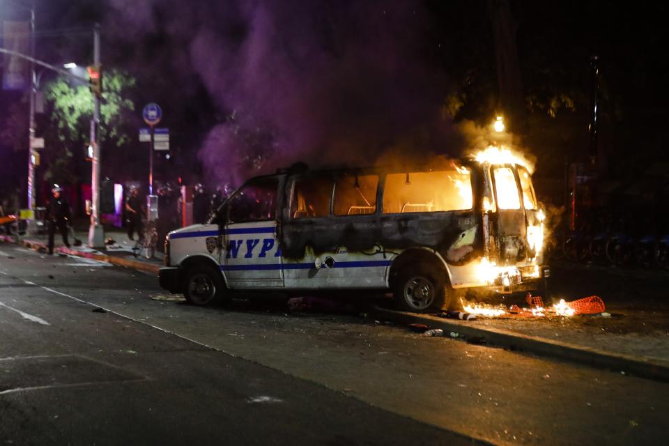 A Police vehicle burns after protesters rallied at Barclays Center over the death of George Floyd, a black man who died Memorial Day while in Minneapolis police custody, Friday, May 29, 2020, in the Brooklyn borough of New York. (AP Photo/Frank Franklin II)