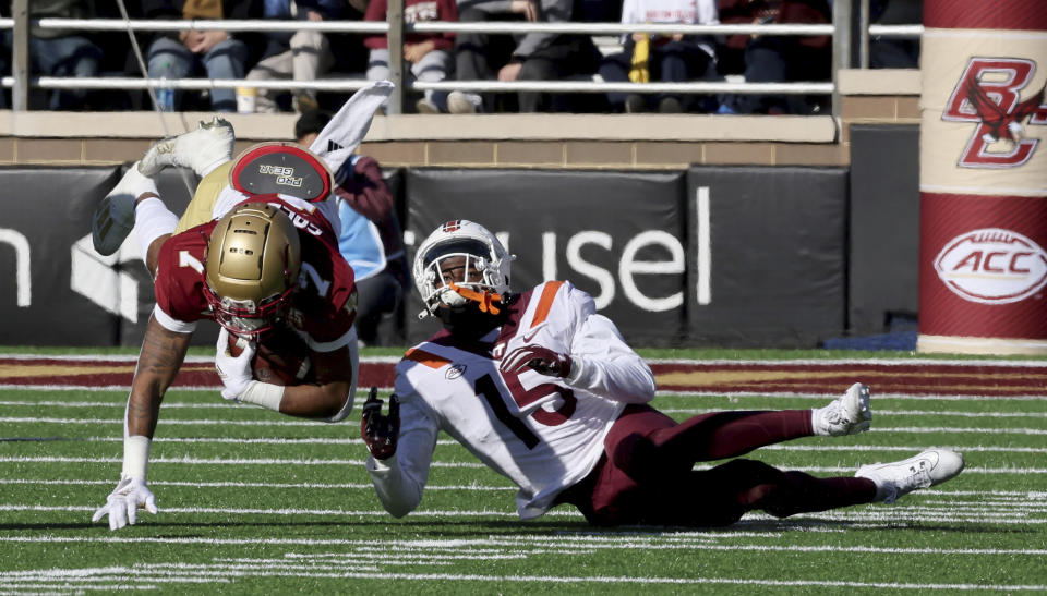 Boston College running back Xavier Coleman (7) dives past Virginia Tech safety Jaylen Jones (15) for a short gain during the first half of an NCAA college football game Saturday, Nov. 11, 2023 in Boston. (AP Photo/Mark Stockwell)