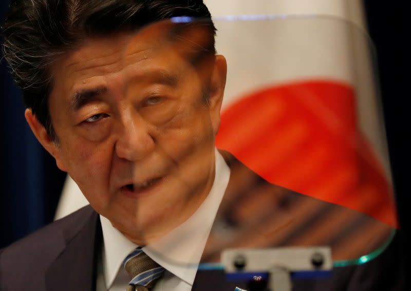 FILE PHOTO: Japan's Prime Minister Shinzo Abe is seen through a prompter as he speaks at a news conference in Tokyo