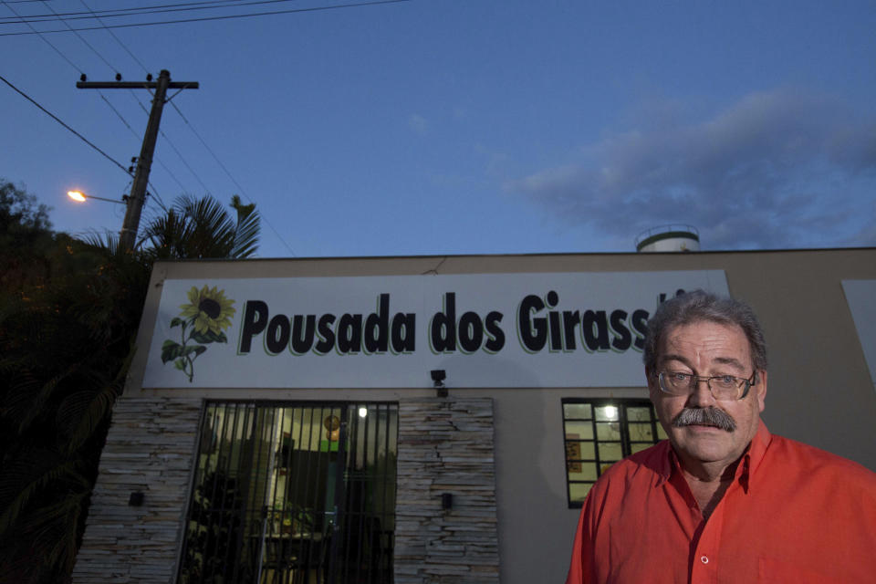 In this Jan. 3, 2019 photo, inn owner Claudio Pruja stands outside his hostel in Abadiania, Brazil, home to Brazilian spiritual healer Joao Teixeira de Faria, who has been arrested facing allegations of sexual abuse. The people in the small city where he worked are in disbelief and fear for the future without him. "All of Abadiania depended on the work of Joao," said Pruja. (AP Photo/Eraldo Peres)