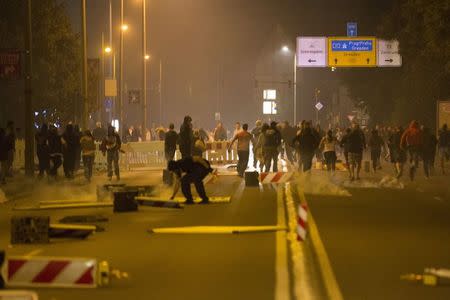 Right wing protesters who are against bringing asylum seekers to an accomodation facility run down a street in Heidenau, Germany August 22, 2015. REUTERS/Axel Schmidt