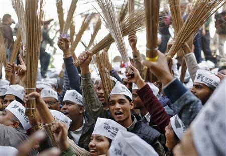 Supporters of Arvind Kejriwal, leader of the newly formed Aam Aadmi (Common Man) Party, hold brooms, the party's symbol, after Kejriwal's election win against Delhi's chief minister Sheila Dikshit, in New Delhi December 8, 2013. REUTERS/Anindito Mukherjee