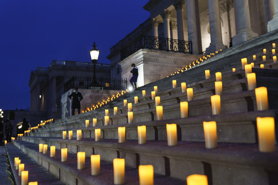 Candles are placed before a moment of silence on the steps of the Capitol to mark the one year anniversary of the violent insurrection by supporters of then-President Donald Trump, in Washington, Thursday, Jan. 6, 2022. (AP Photo/J. Scott Applewhite)