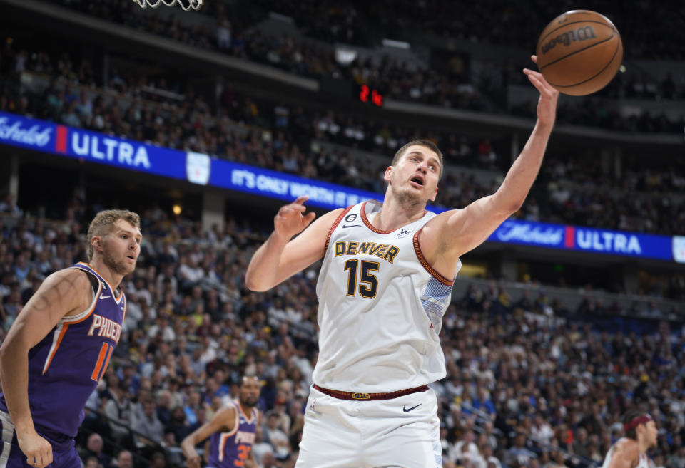 Denver Nuggets center Nikola Jokic, right, reaches for a rebound as Phoenix Suns center Jock Landale watches during the second half of Game 5 of an NBA Western Conference basketball semifinal playoff series Tuesday, May 9, 2023, in Denver. (AP Photo/David Zalubowski)