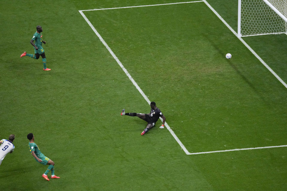 England's Harry Kane, left, scores during the World Cup round of 16 soccer match between England and Senegal, at the Al Bayt Stadium in Al Khor, Qatar, Sunday, Dec. 4, 2022. (AP Photo/Darko Bandic)