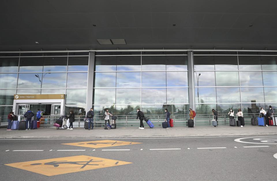 Passengers social distance as they stand in line for a domestic, commercial flight at El Dorado airport in Bogota, Colombia, Tuesday, Sept. 1, 2020. Airports, land transport, restaurants, and gyms are reopening in most of Colombia this week, as the South American nation attempts to reignite its economy following months of restrictions related to the coronavirus pandemic. (AP Photo/Fernando Vergara)