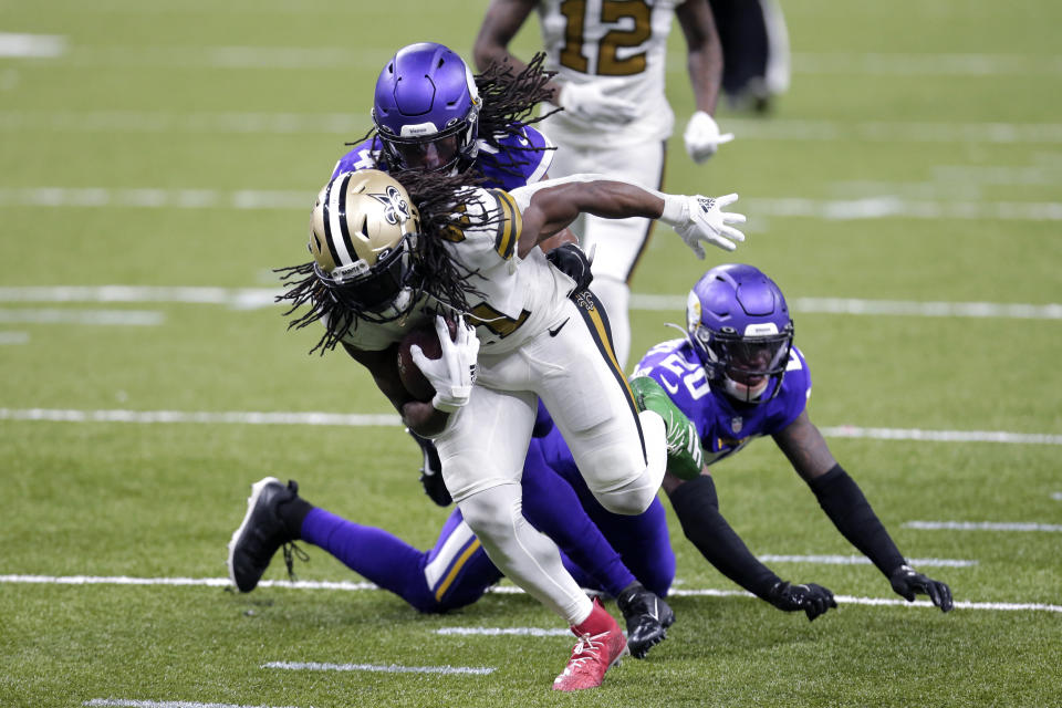 New Orleans Saints running back Alvin Kamara (41) carries against Minnesota Vikings cornerback Jeff Gladney (20) and free safety Anthony Harris in the second half of an NFL football game in New Orleans, Friday, Dec. 25, 2020. (AP Photo/Brett Duke)