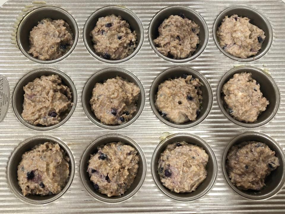 A muffin pan filled with blueberry-bran muffin batter. 