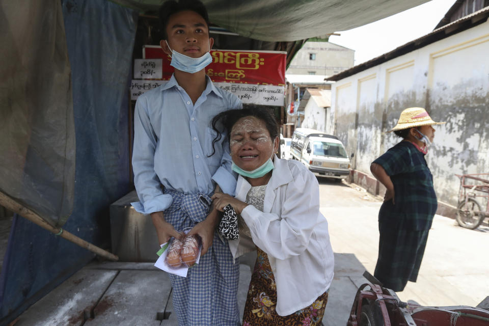 A mother cries after her son, left, is released from Insein prison during a presidential pardon in Yangon, Myanmar, Friday, April 17, 2020. Myanmar says it is releasing almost 25,000 prisoners under a presidential amnesty marking this week's traditional Lunar New Year celebration. (AP Photo/Thein Zaw)