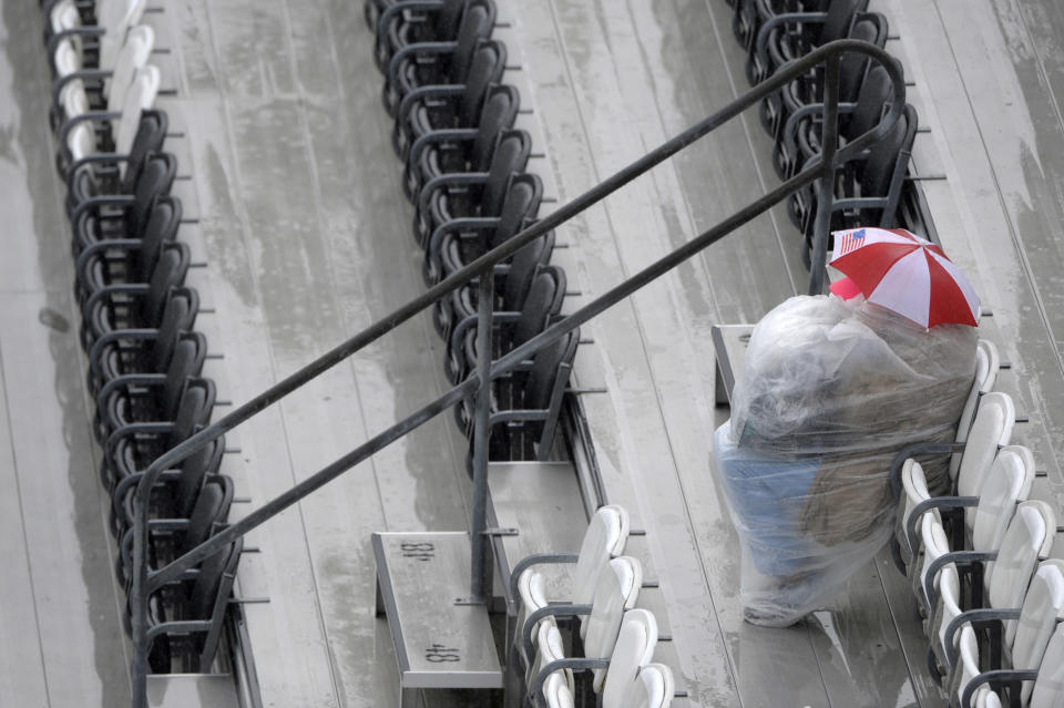 A race fan sits in the grandstand as rain falls on Daytona International Speedway before the NASCAR Daytona 500 auto race in Daytona Beach, Fla., Sunday, Feb. 26, 2012. (AP Photo/Phelan M. Ebenhack)