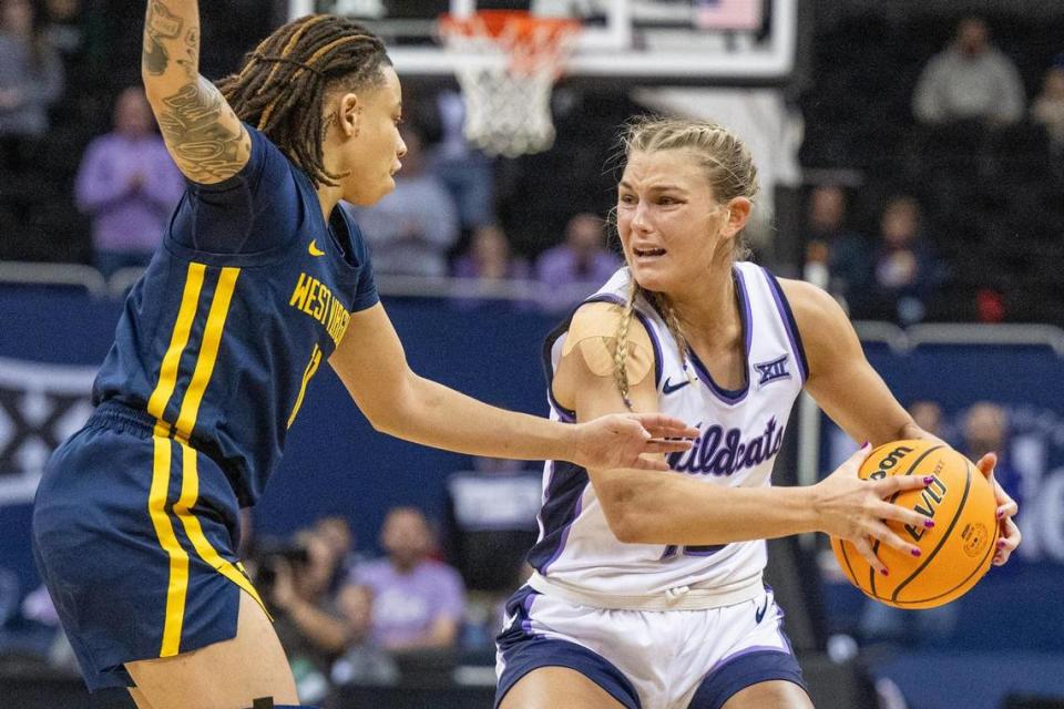Kansas State Wildcats guard Gabby Gregory (12) shields the ball from West Virginia Mountaineers guard JJ Quinerly (11) in the second half of a Big 12 Tournament NCAA women’s basketball game at T-Mobile Center on Saturday, March 9, 2024, in Kansas City.
