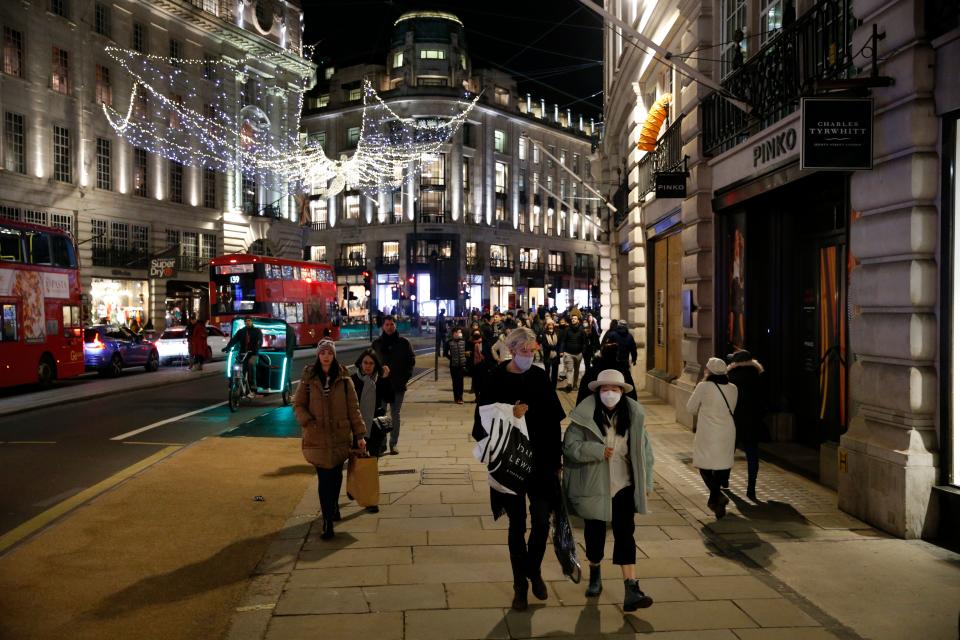 Shoppers walk under the Christmas lights on Regents Street in London on December 6, 2020. - Shoppers returned to Englands high streets this week as shops reopened following the end of a four-week coronavirus lockdown. (Photo by Hollie Adams / AFP) (Photo by HOLLIE ADAMS/AFP via Getty Images)