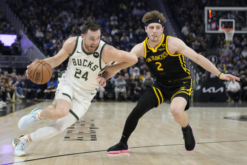 Milwaukee Bucks guard Pat Connaughton (24) drives to the basket against Golden State Warriors guard Brandin Podziemski (2) during the first half of an NBA basketball game in San Francisco, Wednesday, March 6, 2024. (AP Photo/Jeff Chiu)