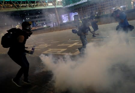 Anti-extradition bill protesters react after the police fired tear gas to disperse the demonstration at Sham Shui Po, in Hong Kong