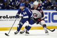 Tampa Bay Lightning center Tyler Motte (64) cuts around Columbus Blue Jackets center Alexandre Texier (42) during the second period of an NHL hockey game Tuesday, April 9, 2024, in Tampa, Fla. (AP Photo/Chris O'Meara)