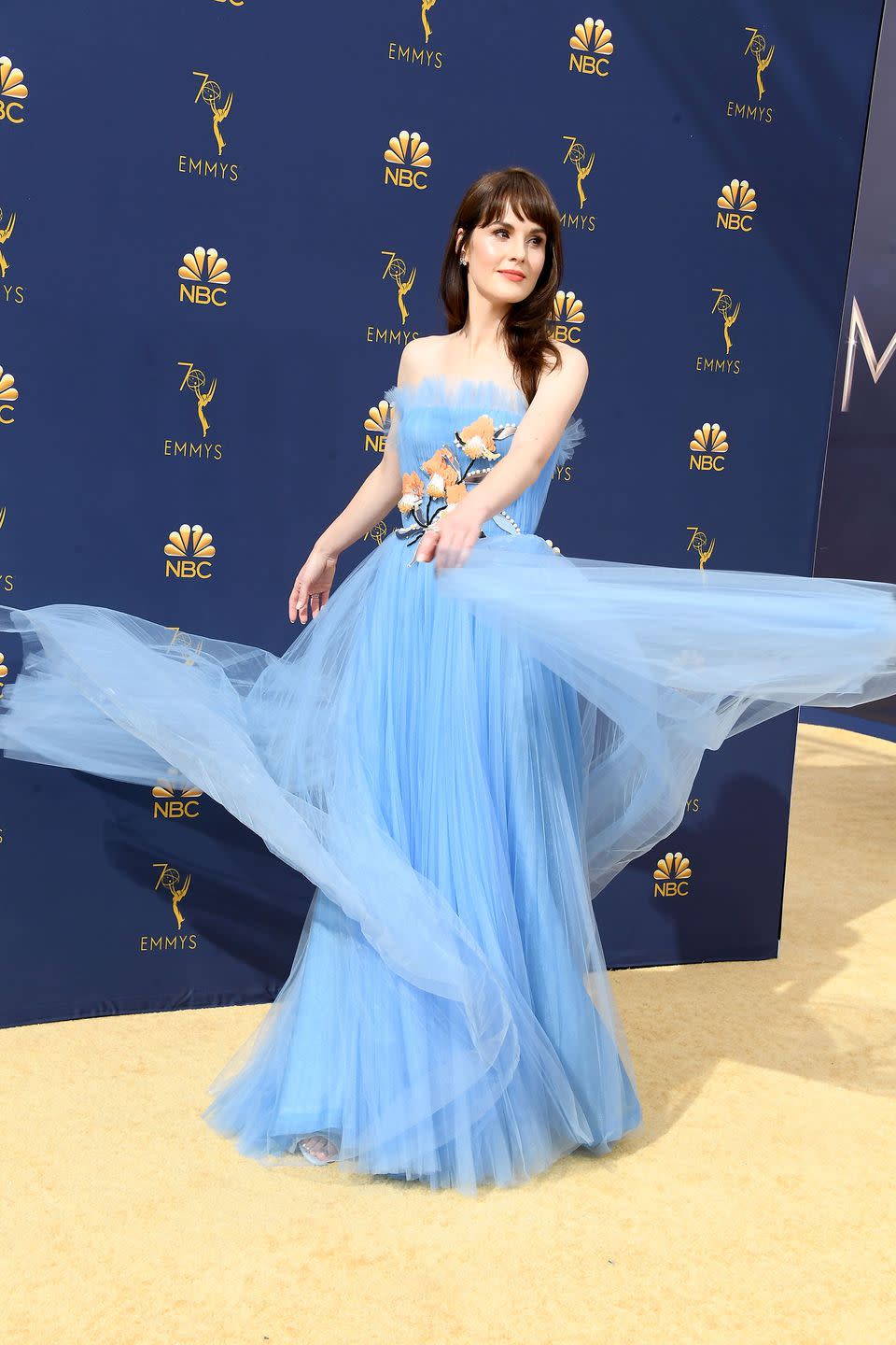 <p>Michelle Dockery made the most of her layered tulle gown as she swished around for the cameras. The frothy strapless dress, which also featured embroidered flower detail, was designed by Carolina Herrera. </p>