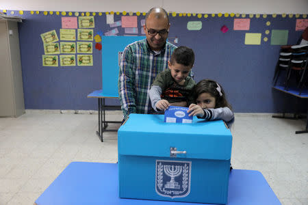 An Israeli-Arab father casts a ballot together with his children, as Israelis vote in a parliamentary election, at a polling station in Umm al-Fahm, Israel April 9, 2019. REUTERS/Ammar Awad