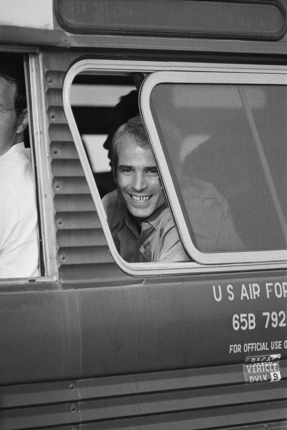 <p>McCain smiles from a bus window on arrival at Clark Air Base in the Philippines, after his release from Hanoi on March 14, 1973.</p>
