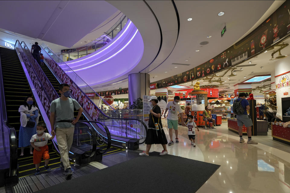 Residents wearing face masks bring their children to a reopened mall after it has been closed due to COVID-19 restrictions in Beijing, Sunday, May 29, 2022. (AP Photo/Andy Wong)