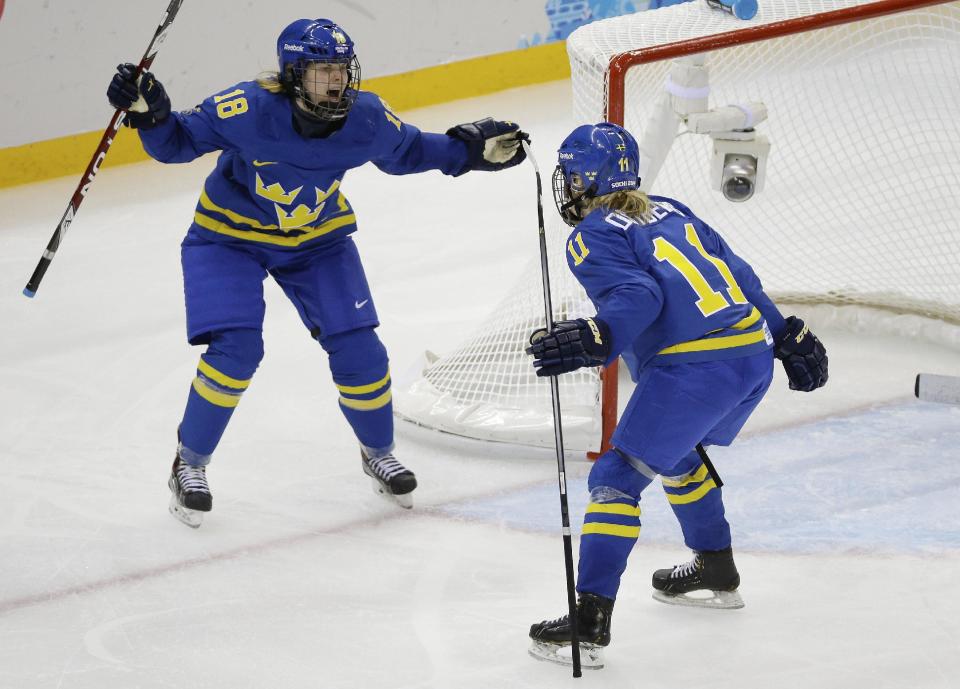 Cecilia Ostberg of Sweden (11) celebrates her goal against Germany with teammate Anna Borgqvist (18) during the third period of the 2014 Winter Olympics women's ice hockey game at Shayba Arena, Tuesday, Feb. 11, 2014, in Sochi, Russia. (AP Photo/Mark Humphrey)