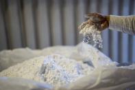 A worker stirs lithium with his hand at the SQM processing plant in Antofagasta, Chile, Wednesday, April 19, 2023. (AP Photo/Rodrigo Abd)