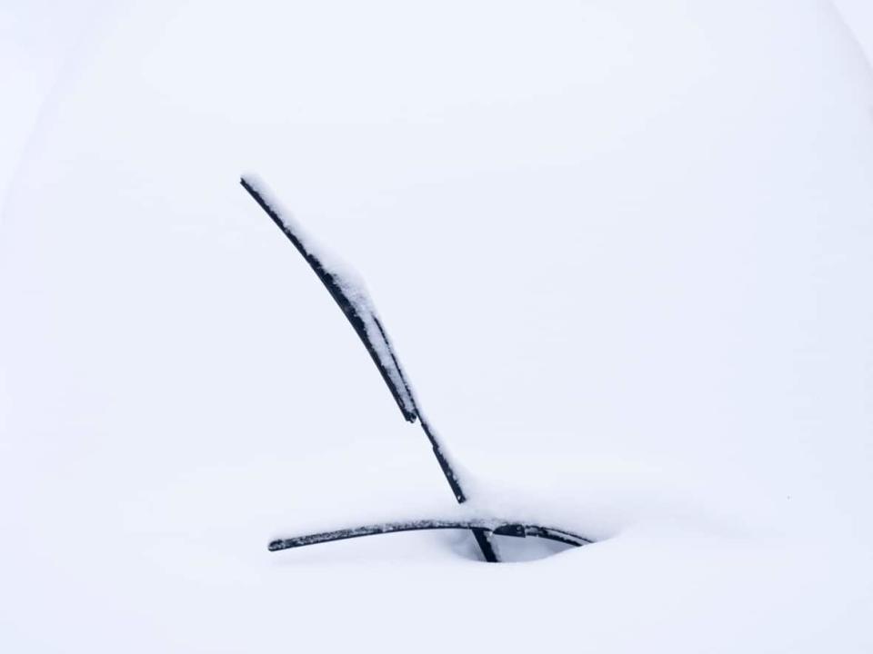 Windshield wipers peek out of a blanket of snow on a parked car Dec.16, 2022 in Chelsea, Que. (Adrian Wyld/The Canadian Press - image credit)