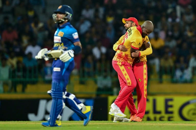 Zimbabwe's Luke Jongwe celebrates with Sikandar Raza (R) after taking the wicket of Sri Lanka's Kusal Mendis (L) during the second T20 between Sri Lanka and Zimbabwe (Ishara S. KODIKARA)