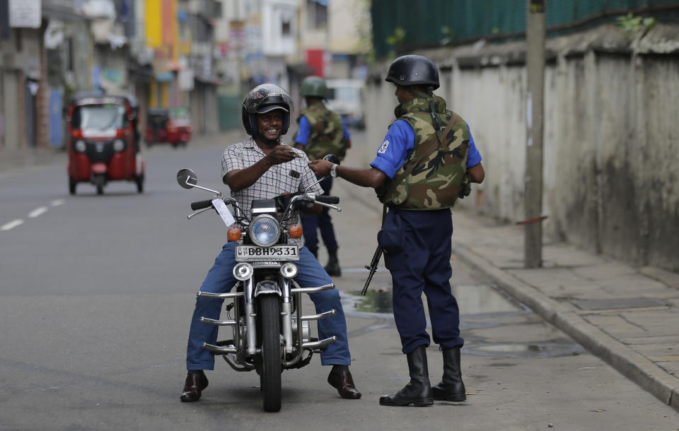 Sri Lankan naval soldiers check the identity of a motorists in Colombo, Sri Lanka, Wednesday, May 1, 2019. Sri Lanka's major political parties called off traditional May Day rallies due to security concerns following the Easter bombings that killed more than 250 people and were claimed by militants linked to the Islamic State group. (AP Photo/Eranga Jayawardena)
