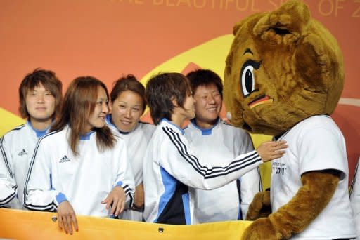 The Japanese women's national football team is greeted by mascot Karla Kick in Bochum, western Germany, on June 22. The Japanese team will play against New Zealand in their women's World Cup Group B match on June 27, in Bochum