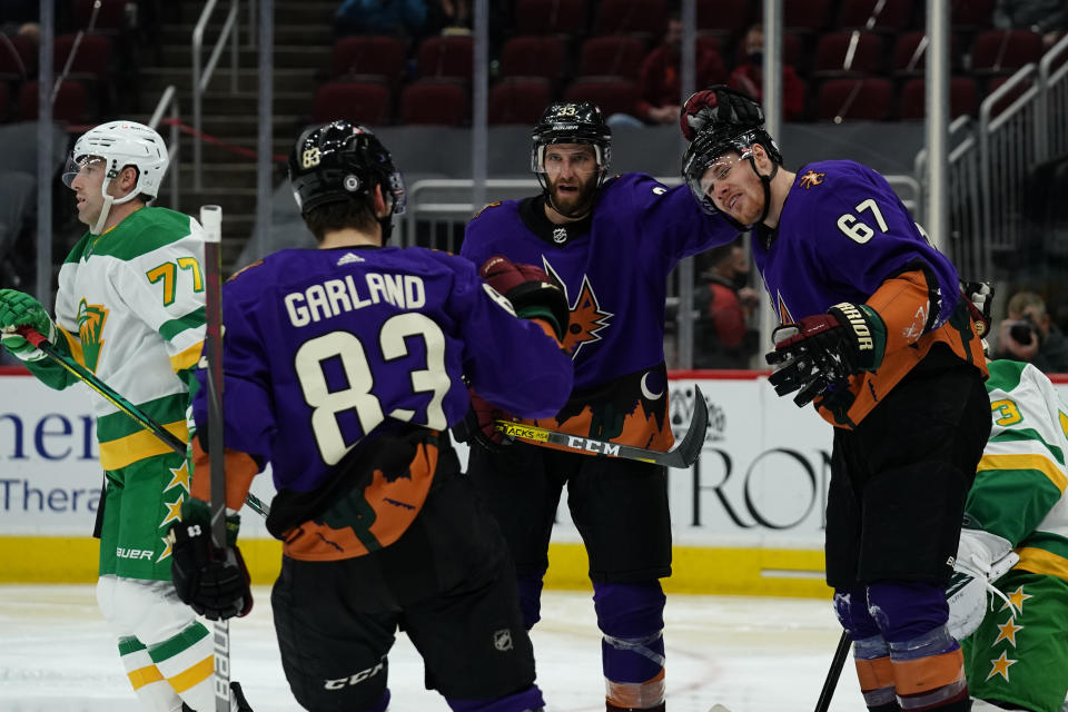 Arizona Coyotes left wing Lawson Crouse (67) celebrates with right wing Conor Garland (83) and defenseman Alex Goligoski (33) after scoring a goal against the Minnesota Wild in the second period during an NHL hockey game, Saturday, March 6, 2021, in Glendale, Ariz. (AP Photo/Rick Scuteri)