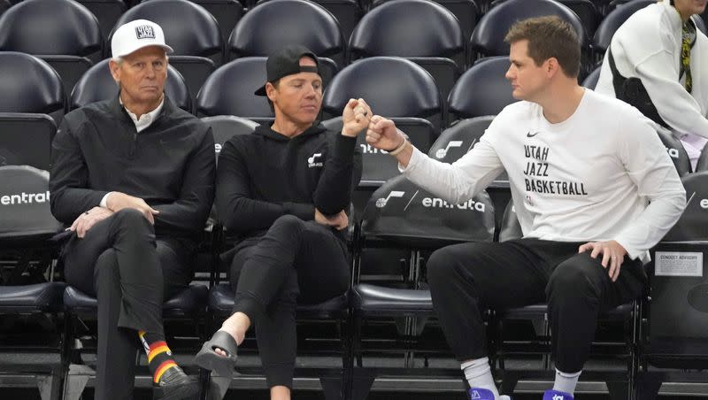 Utah Jazz’s CEO, Danny Ainge, left, looks on as Jazz owner Ryan Smith and head coach Will Hardy fist bump while sitting court side before the start an NBA basketball game against the Oklahoma City Thunder Tuesday, Feb. 6, 2024, in Salt Lake City.