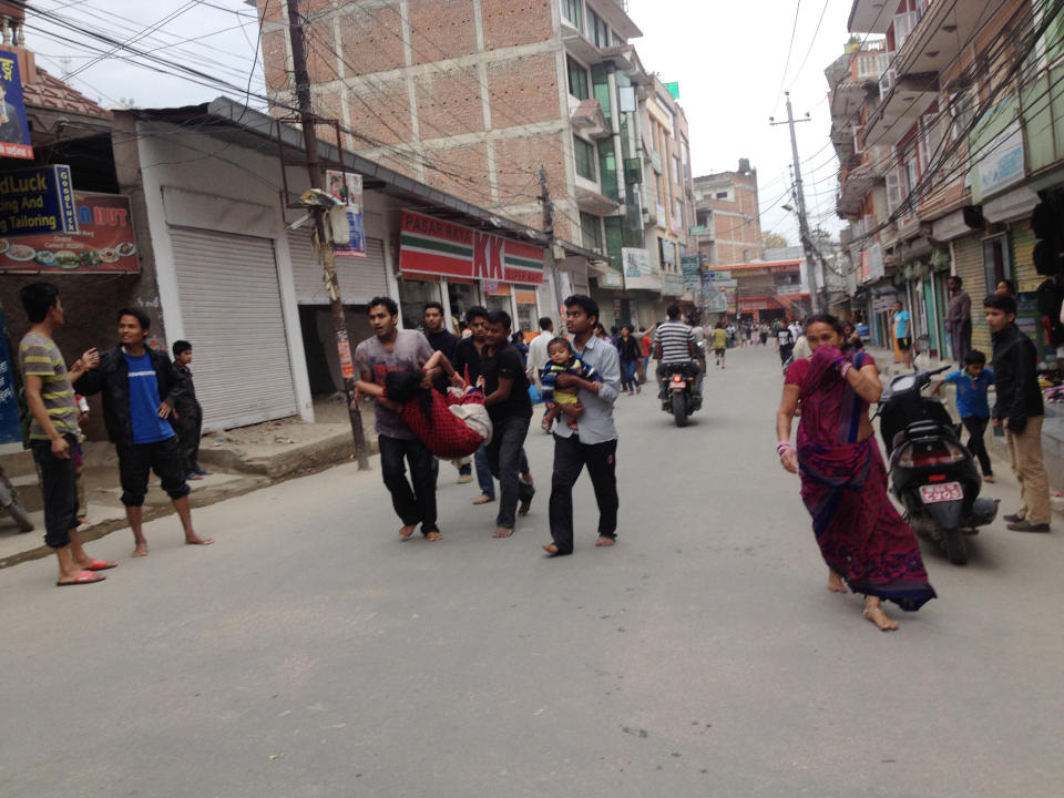 In this photo provided by Guna Raj Luitel, an injured woman is carried just after the earthquake in Kathmandu, April 25, 2015. (Guna Raj Luitel via AP)