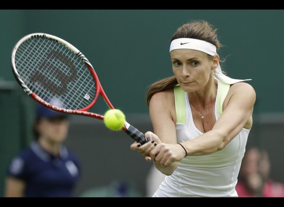 Iveta Benesova of the Czech Republic returns a shot to Heather Watson of Britain during a first round women's singles match at the All England Lawn Tennis Championships at Wimbledon, England, Monday, June 25, 2012.