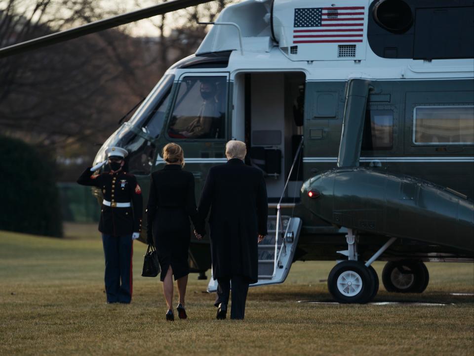 Donald Trump and Melania Trump hold hands as they prepare to depart the White House on Marine One to Florida several hours ahead of the inauguration ceremony. Mr Trump is the first president in more than 150 years to refuse to attend their successor's inaugurationGetty Images