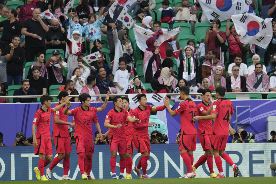 South Korea's Son Heung-min, center, celebrates with teammates after scoring a penalty, the opening goal of his team, during the Asian Cup Group E soccer match between Jordan and South Korea at Al Thumama in Doha, Qatar, Saturday, Jan. 20, 2024. (AP Photo/Aijaz Rahi)